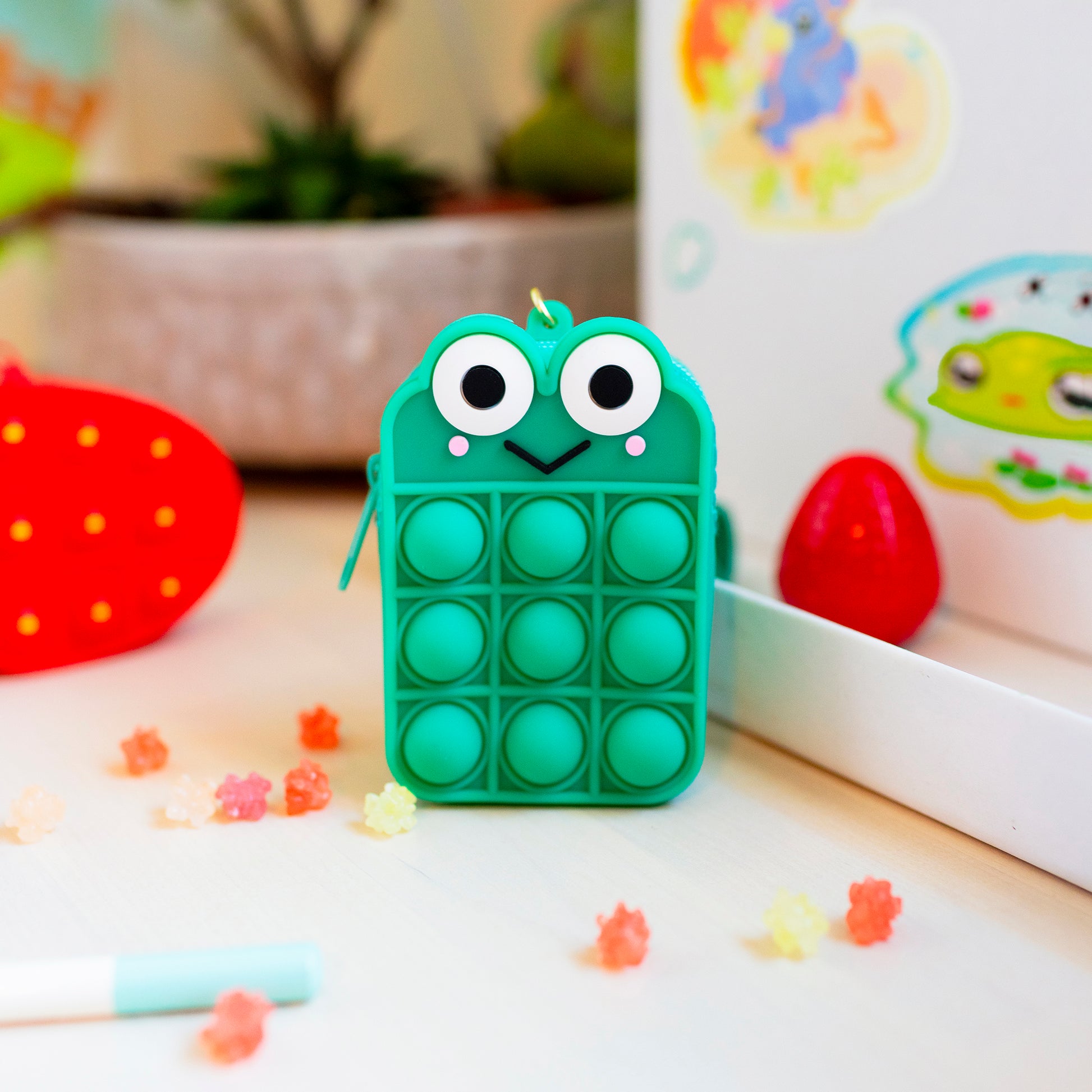 Frog pop it fidget toy shown as part of cute desk setup