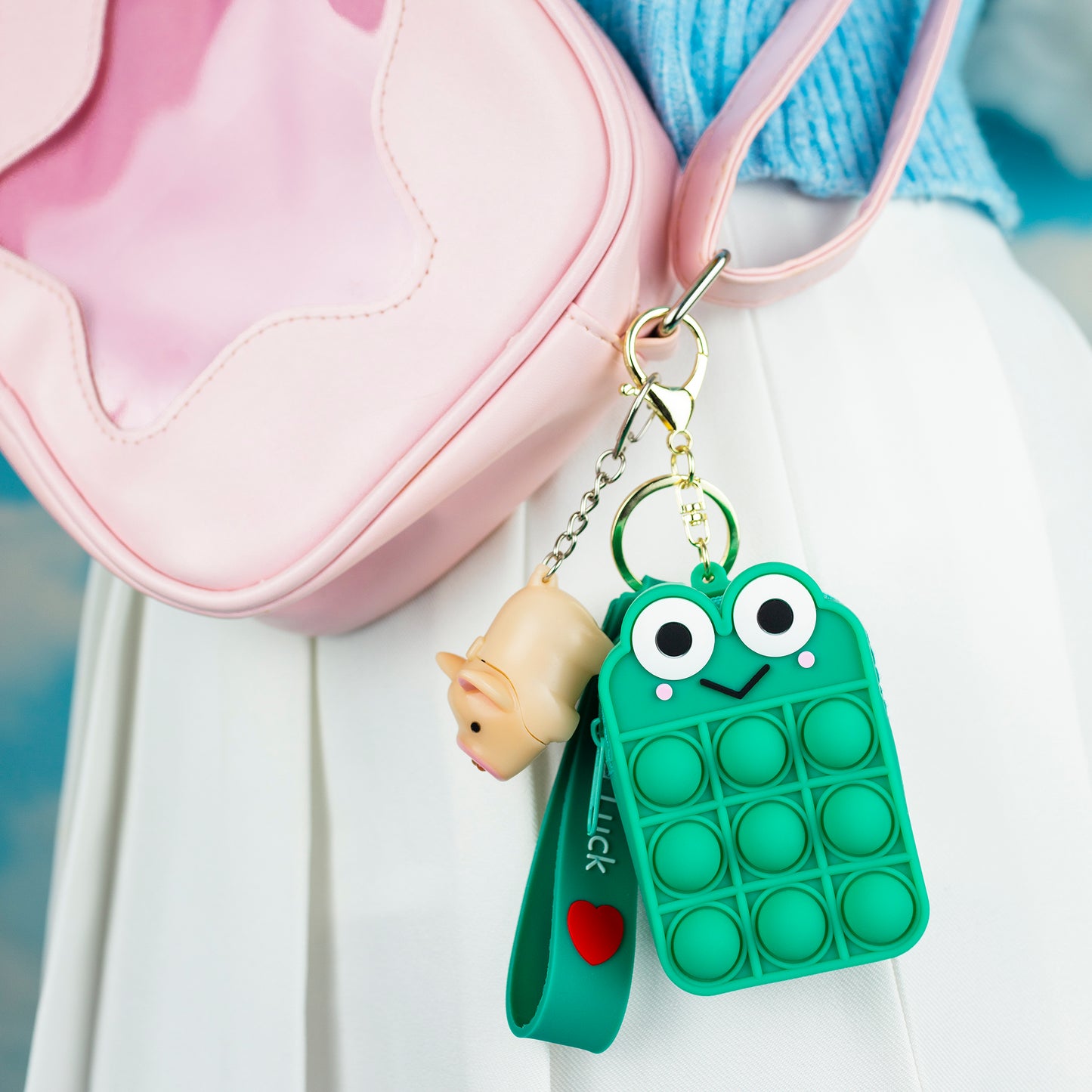 frog pop it fidget toy with keychain clasp shown clipped to a bag