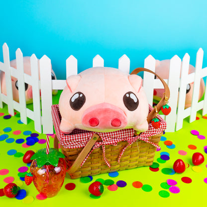 Kawaii plushie piggy stuffed animal inside a picnic basket in front of a white fence