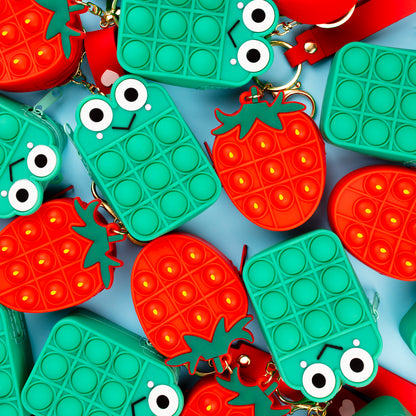 strawberry pop it and frog fidget toys placed together